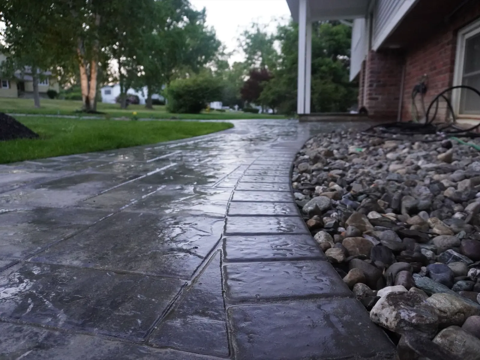 Paver walkway with a cobble-style border curving along the front of a home